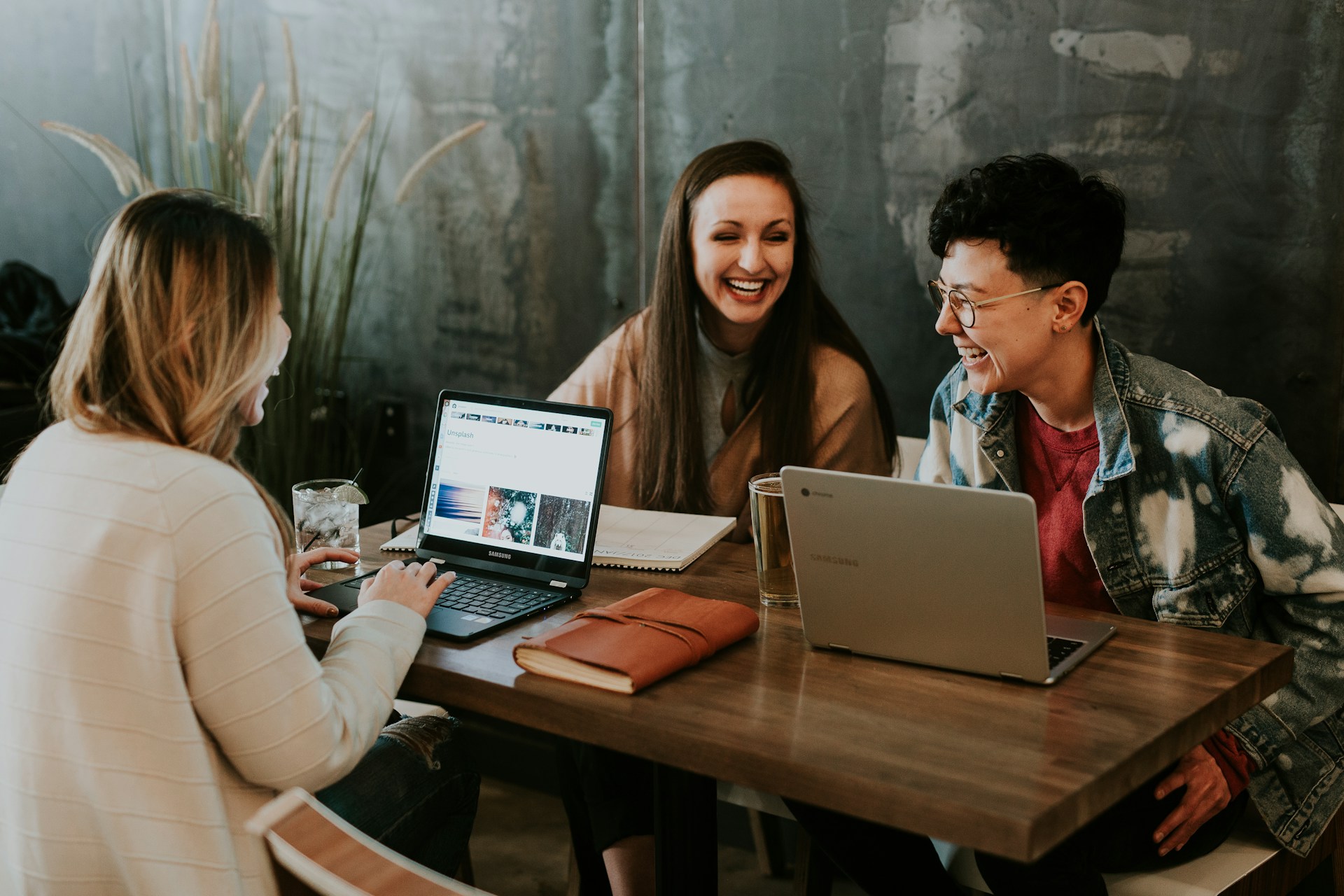 Smiling colleagues sharing ideas around a table, illustrative stock photograph
